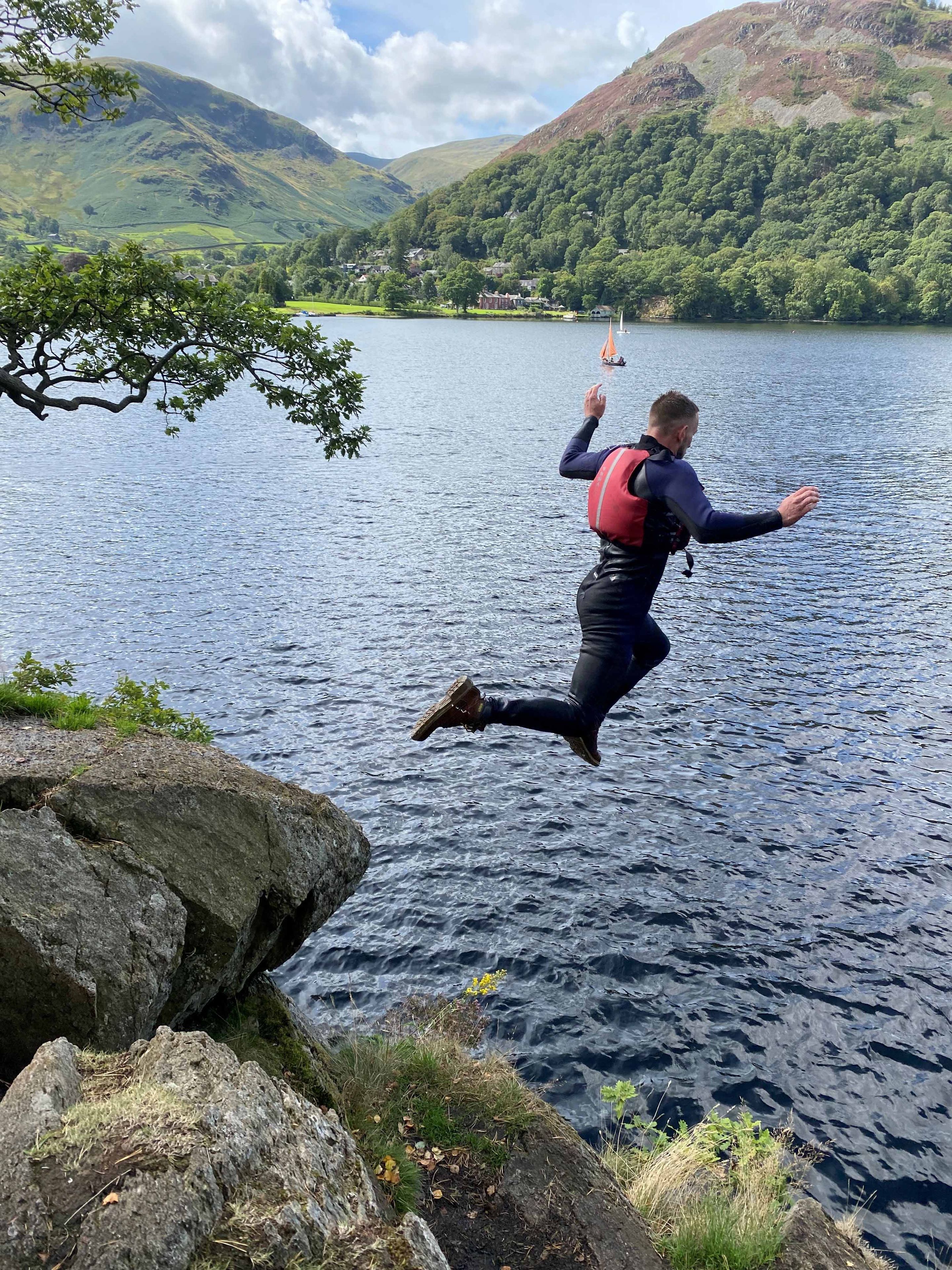 man jumping in lake