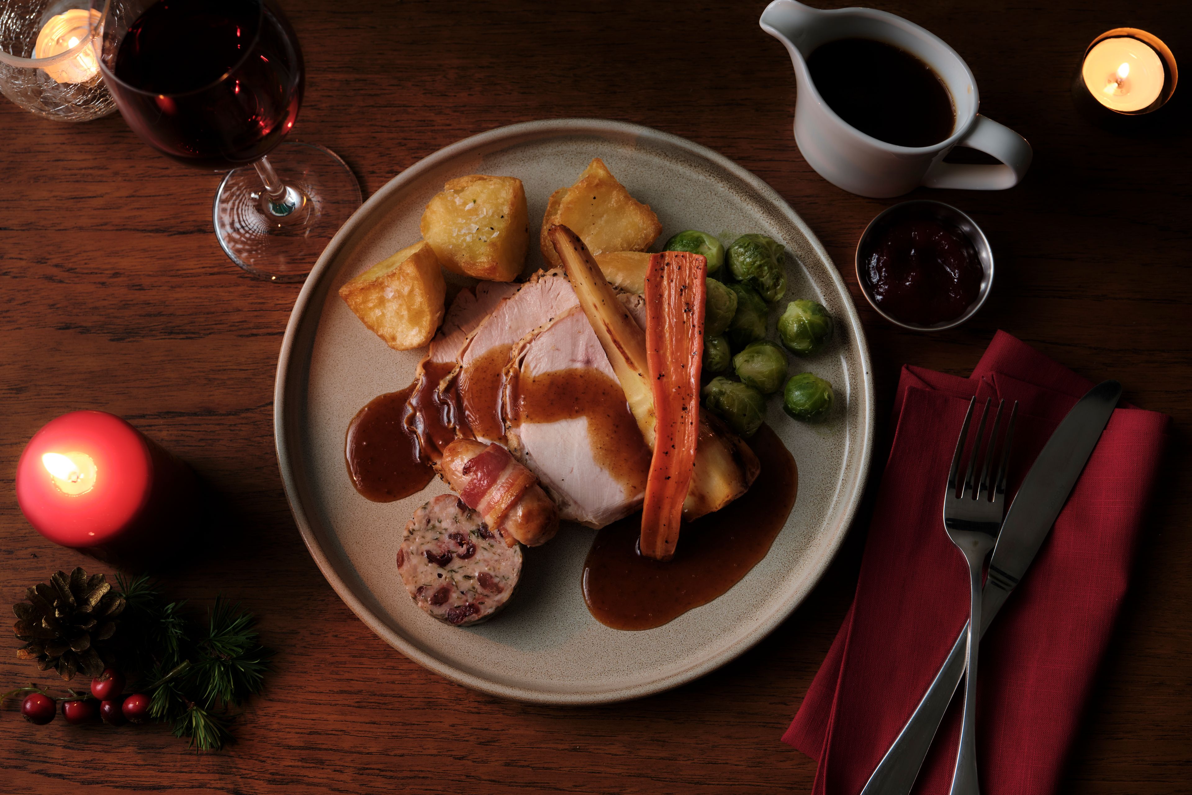 festive turkey dish with carrots, brussel sprouts, potatoes, stuffing, pigs in blankets and gravy